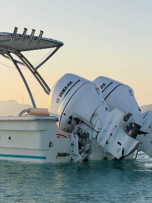 Bote privado con motores Yamaha en aguas turquesa al atardecer